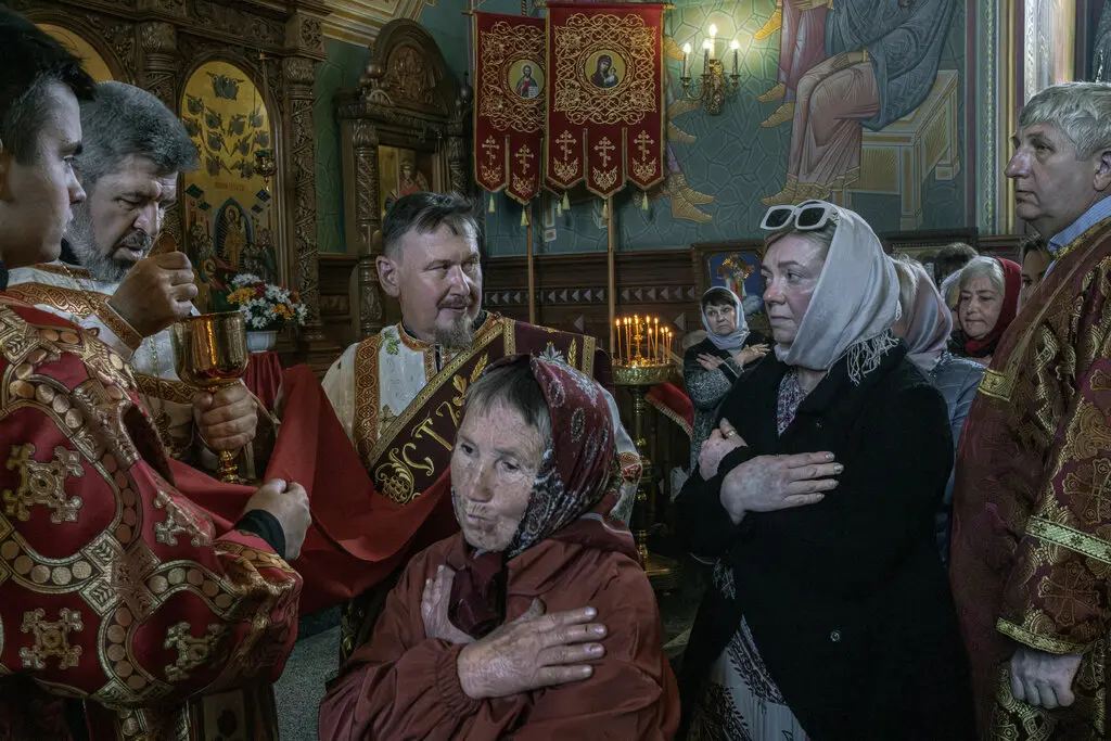 Російські православні віруючі причащаються від священика під час пасхальної служби, яка проводиться в церкві Московського патріархату в Костянтинівці, на сході України, у травні.